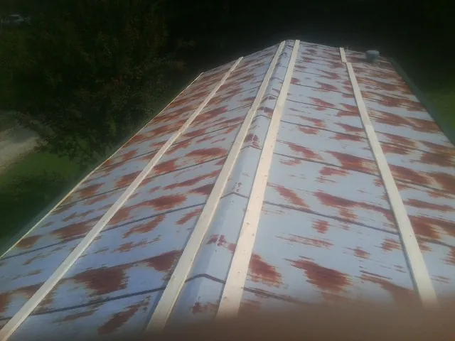 Rusted metal roof panels with new wood purlins before replacement — Storm Damage Roof Repair in Ovando by Roofing Brothers